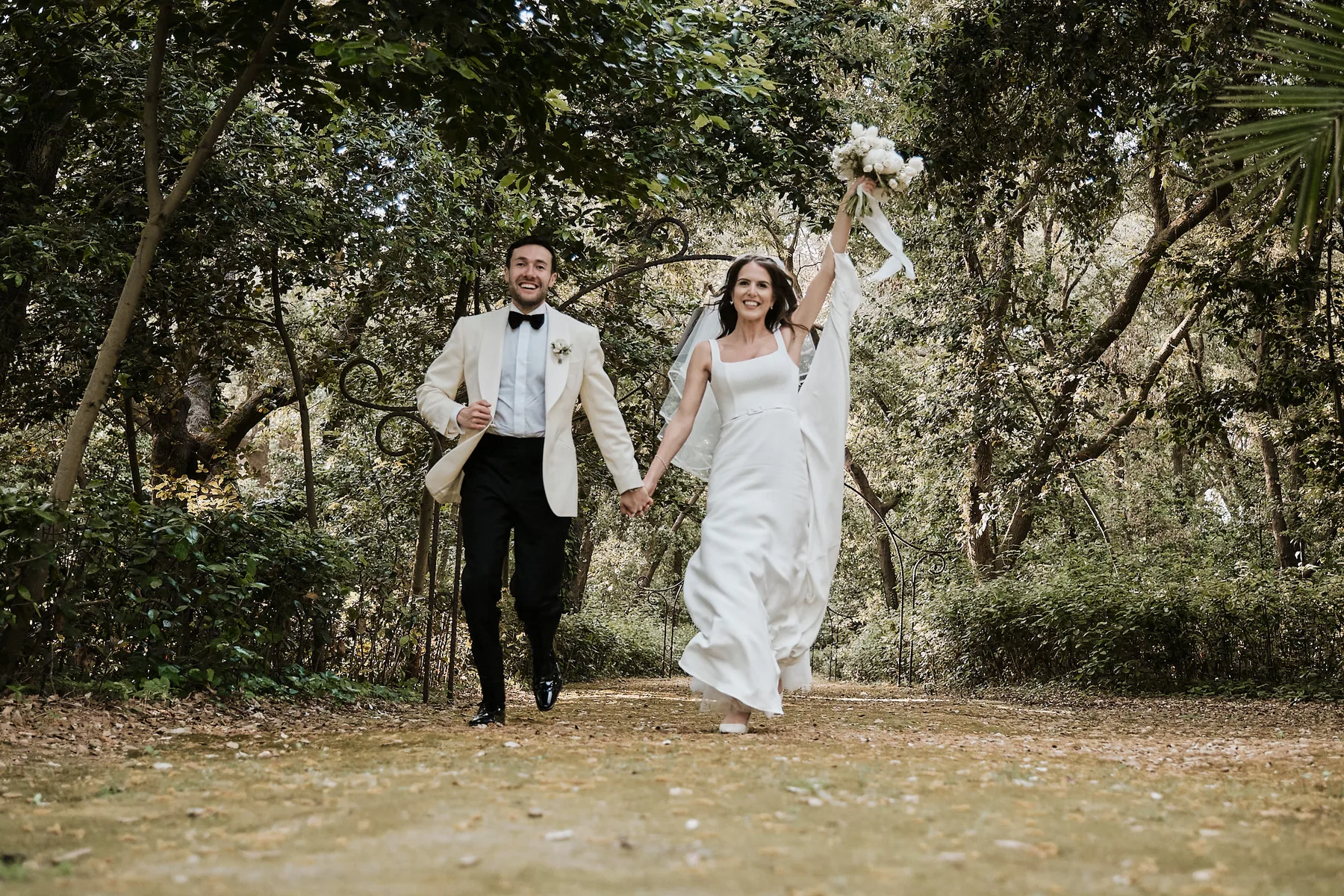 Alex e Daisy escono festeggiando tra gli alberi del giardino di Villa Zaira