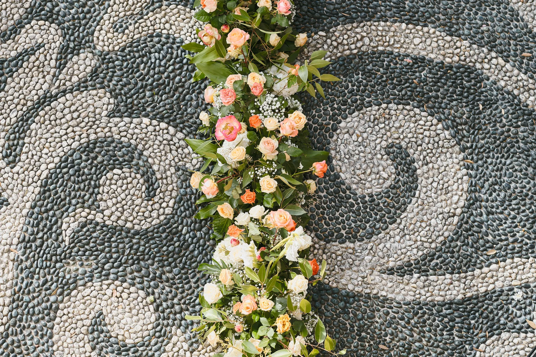 Una ghirlanda di fiori sul pavimento a mosaico di ciottoli