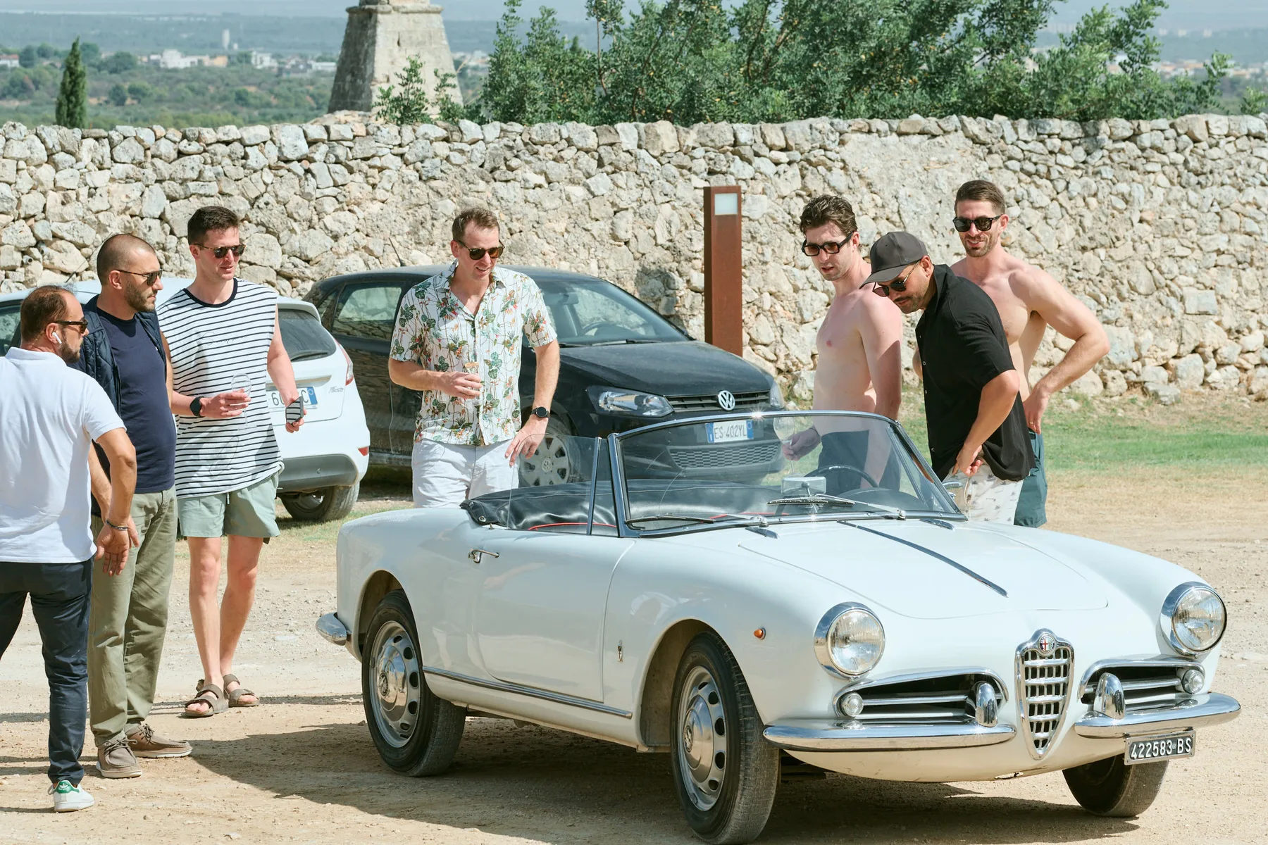 Lo sposo e gli amici accanto a un’auto d’epoca