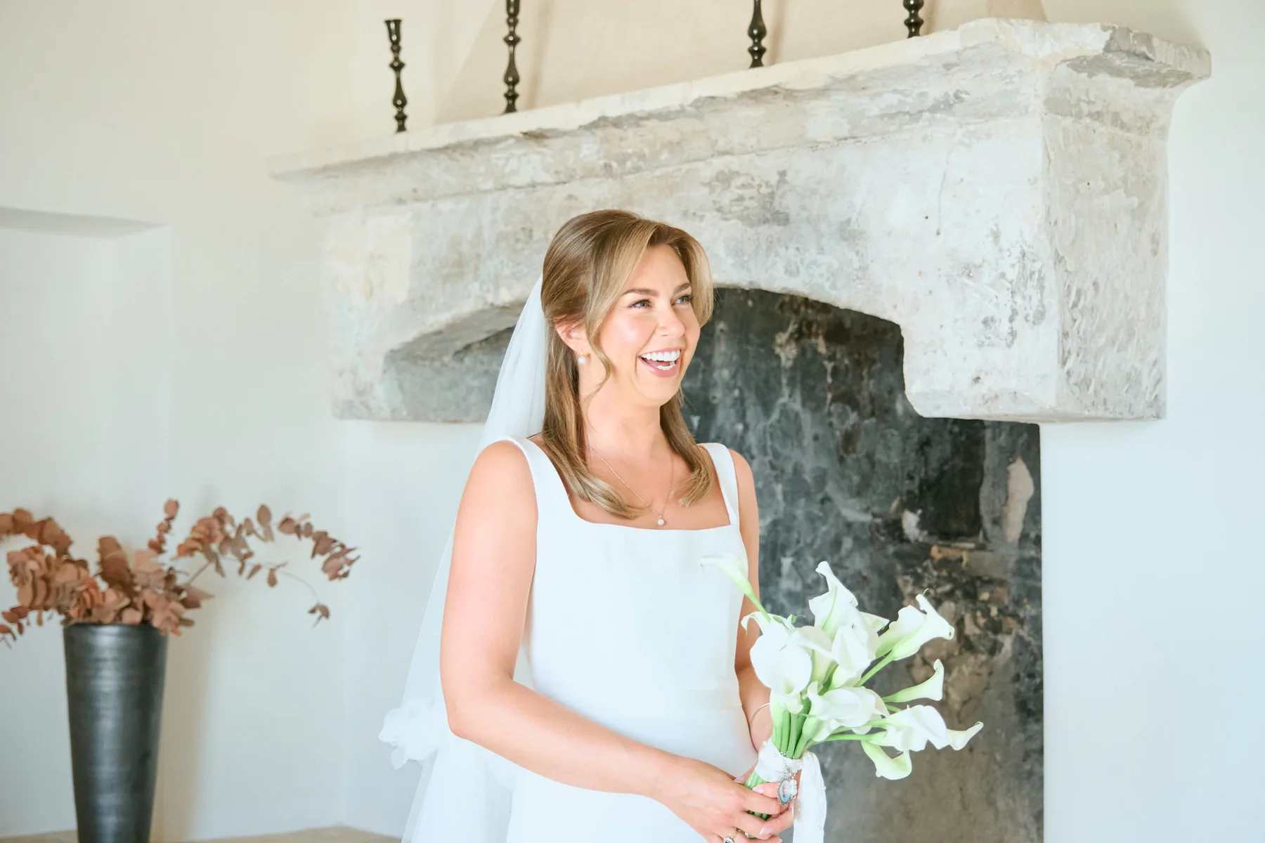 La sposa pronta accanto al camino in pietra