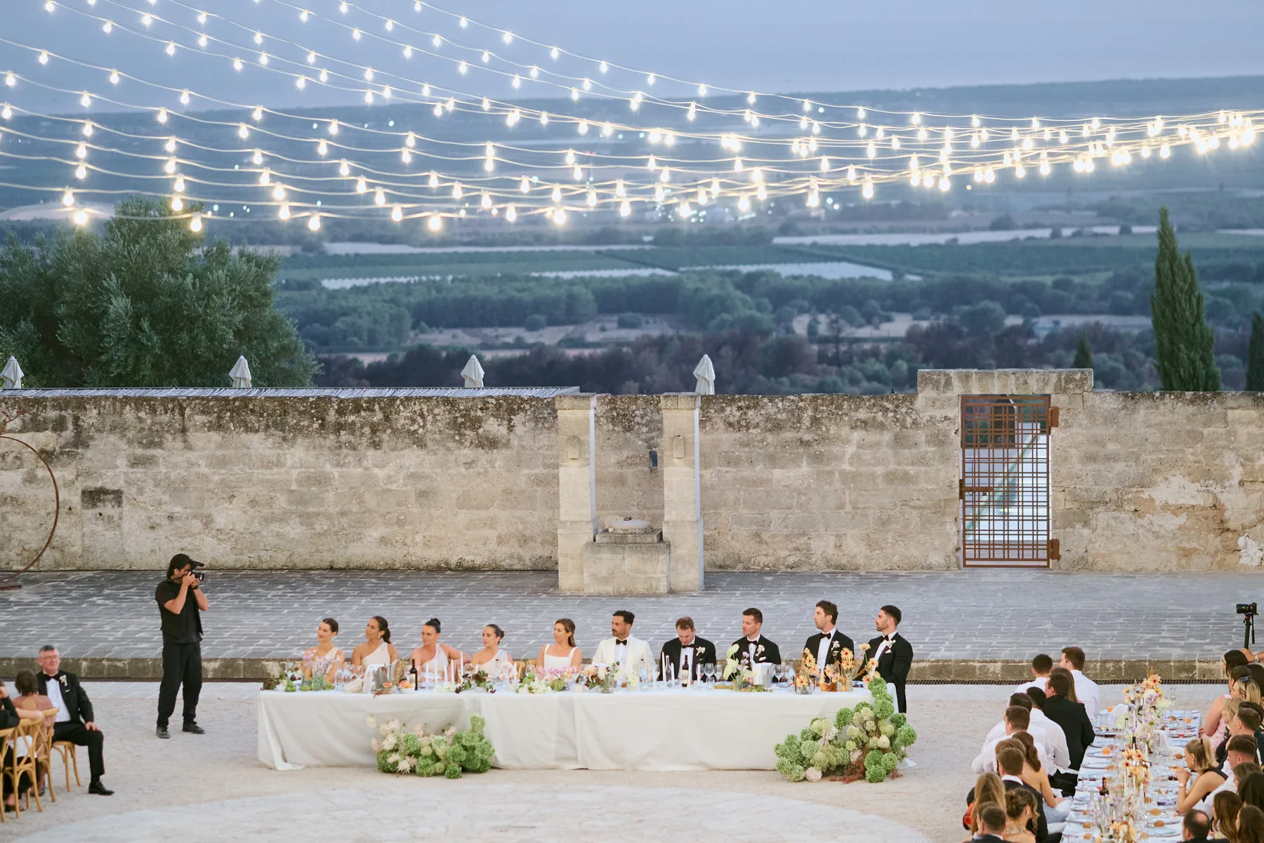 La cena sotto le luci sospese, con la campagna al crepuscolo, ad Amastuola (Massafra)