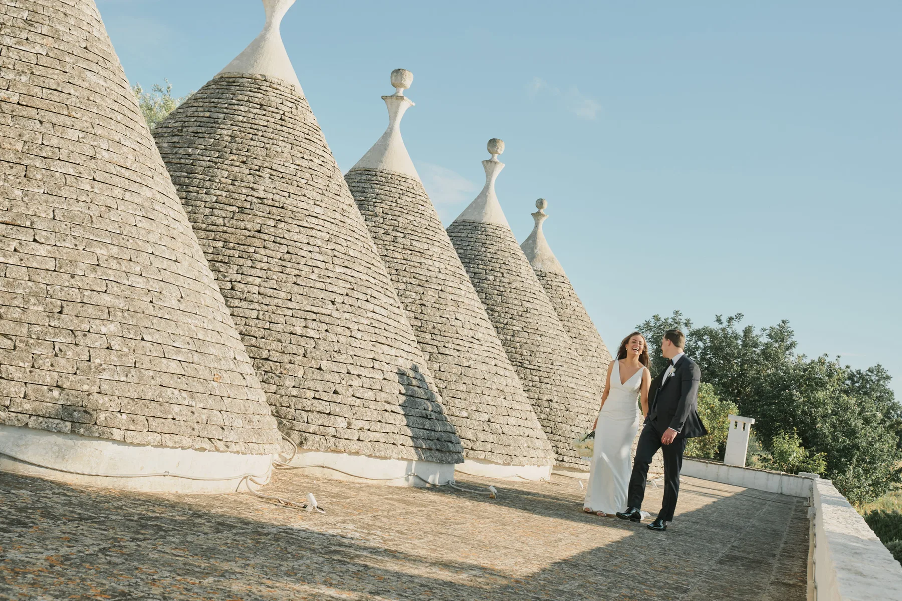 Sarah e Lewis accanto ai coni di pietra dei trulli di Villa Cenci, a Cisternino