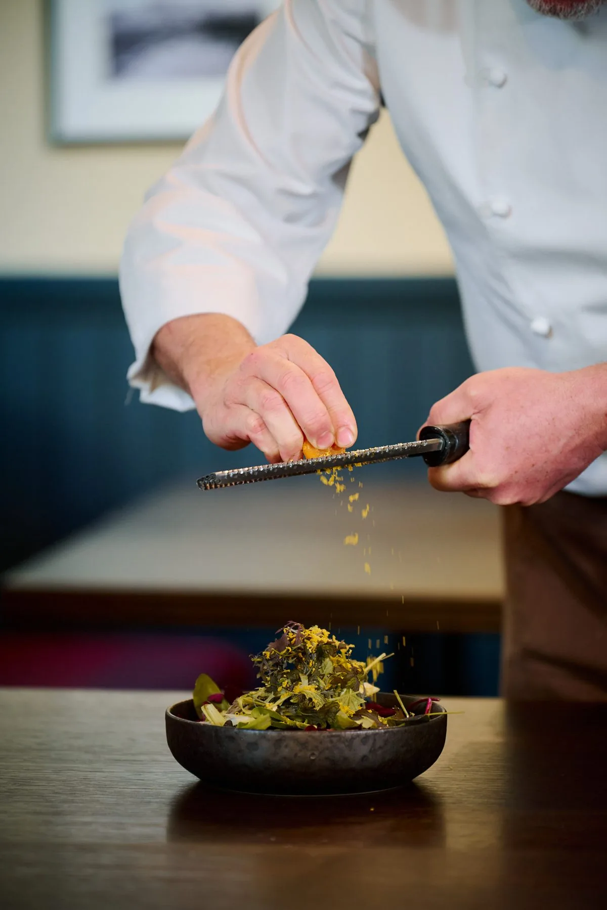 Lo chef impiatta una portata in cucina