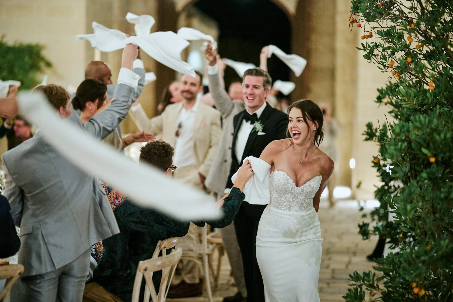 Gli invitati festeggiano sventolando bandiere bianche alla fine della cerimonia