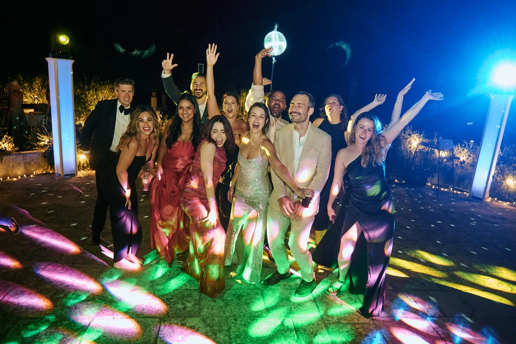 Gli invitati ballano sotto le luci colorate a tarda notte