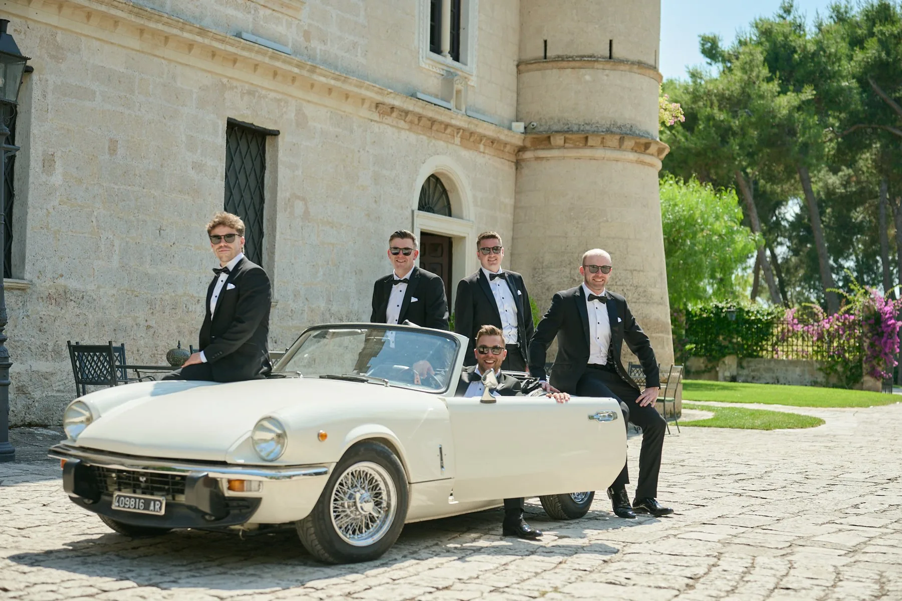 Gruppo di testimoni seduti sull'auto d'epoca davanti a Castello Monaci