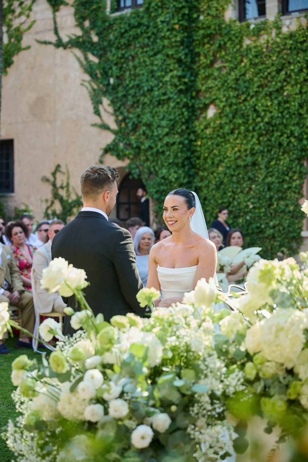 Il momento delle promesse durante la cerimonia, tra i fiori bianchi